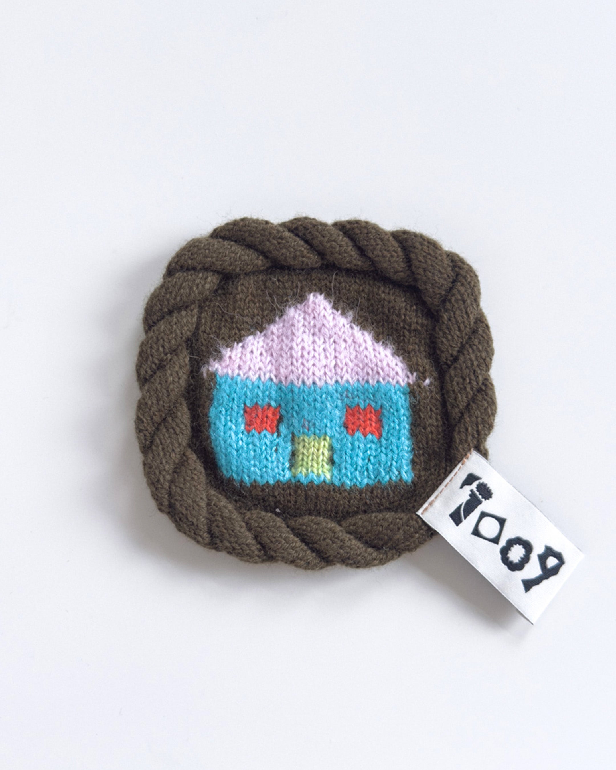 knit house coaster with colorful wool design and rope border
handmade wool coaster with house motif on white background
close-up of textured knit coaster with house pattern