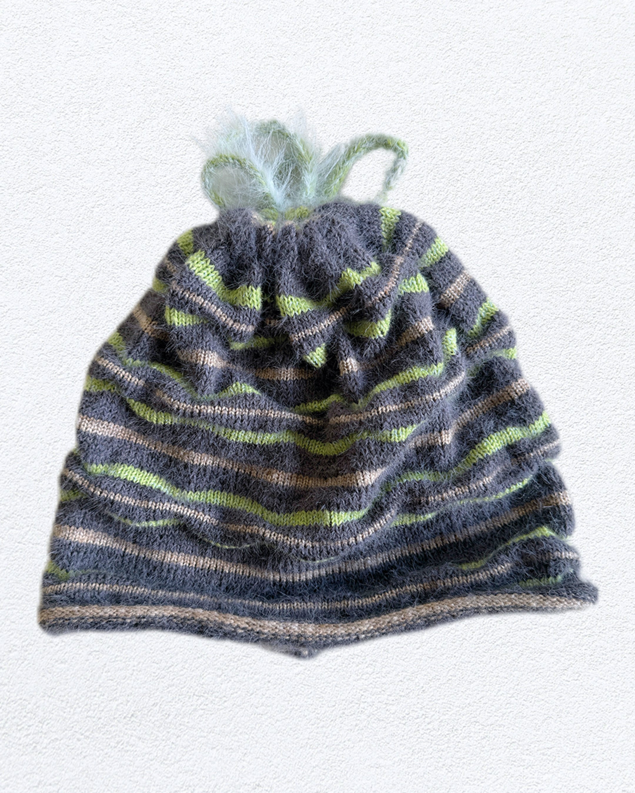 3d knit beanie with textured pattern worn on model
close-up of reversible knit beanie in brown and yellow stripes
side profile of wool mohair beanie with sculptural texture