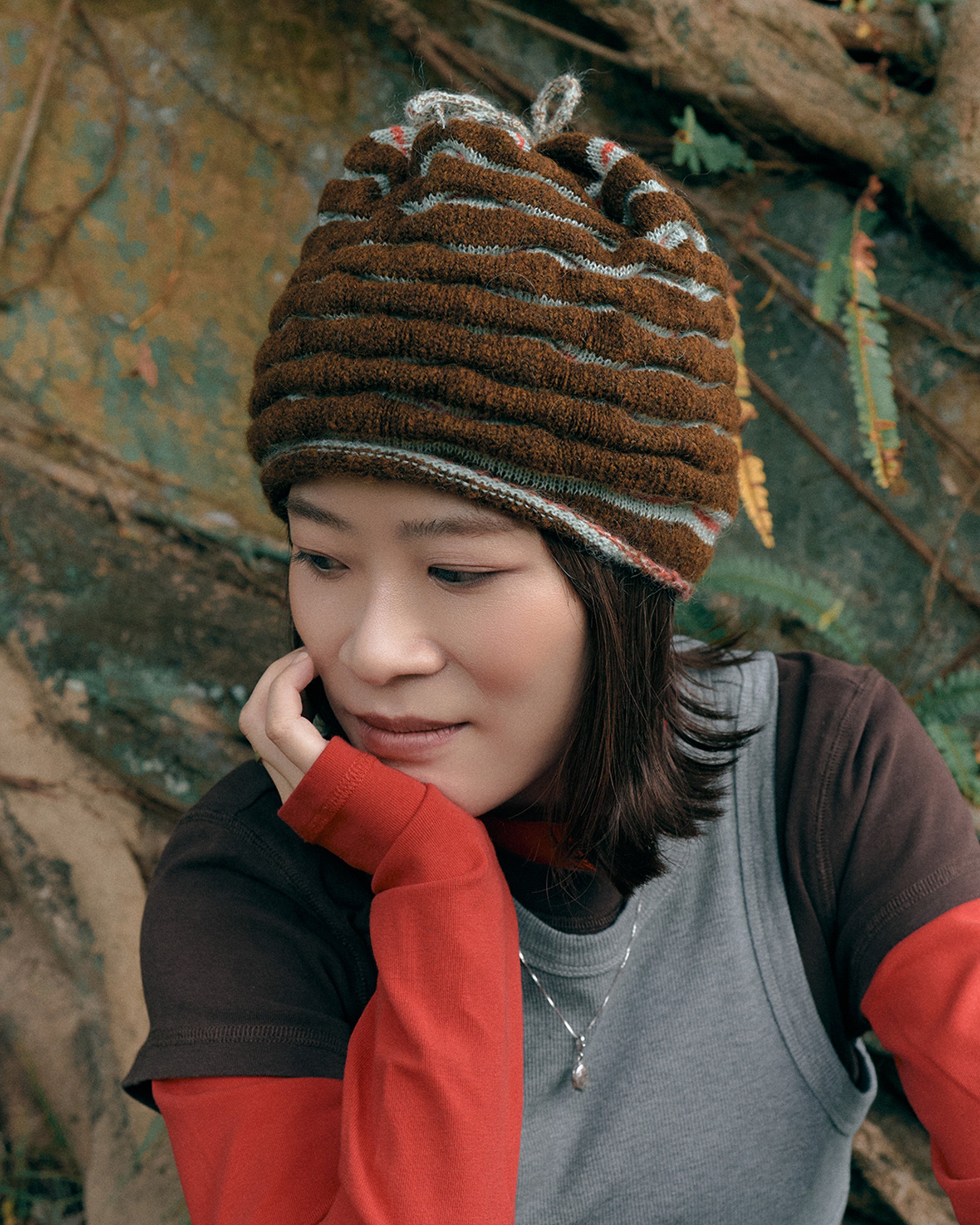3d knit beanie with textured pattern worn on model
close-up of reversible knit beanie in brown and yellow stripes
side profile of wool mohair beanie with sculptural texture