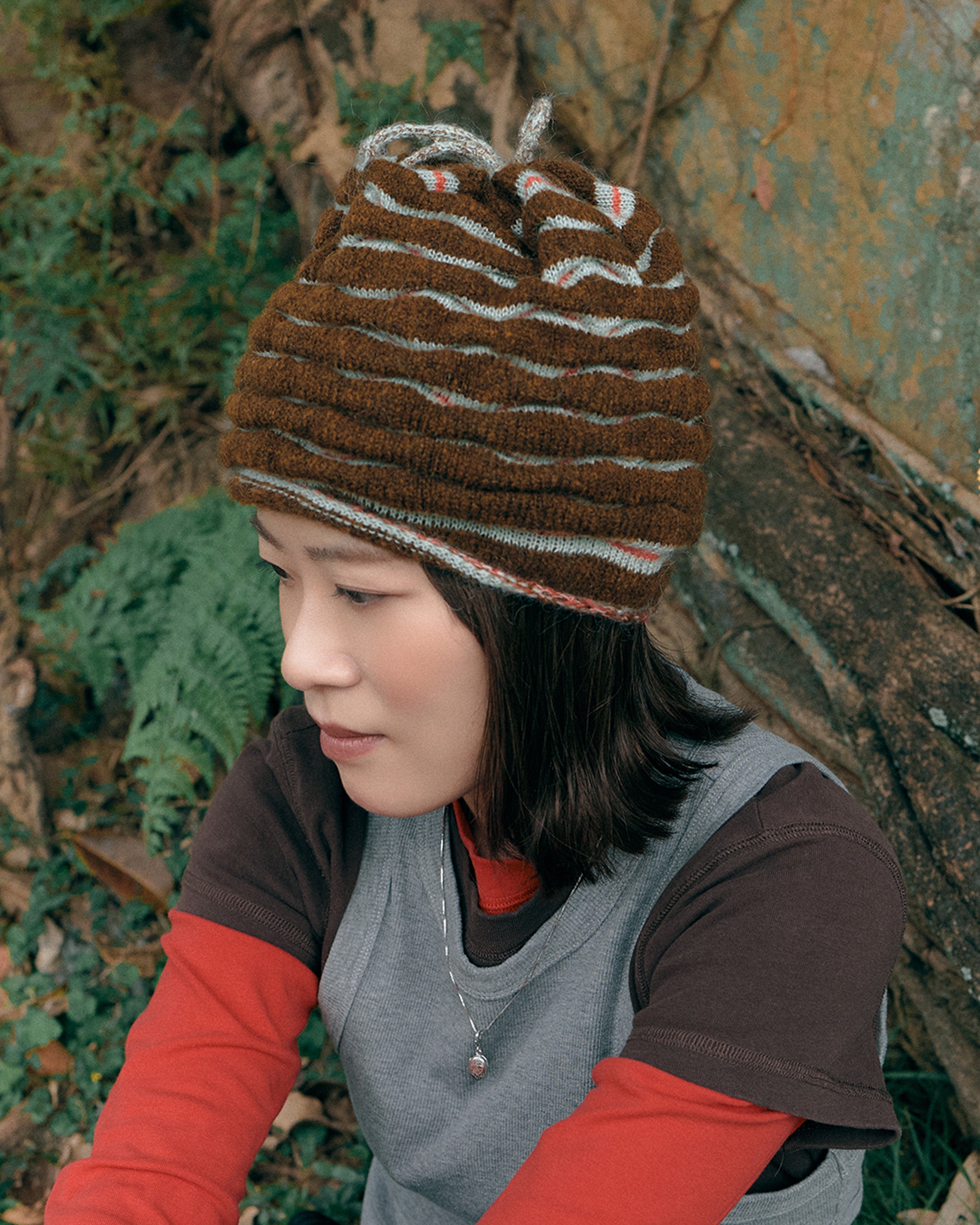 3d knit beanie with textured pattern worn on model
close-up of reversible knit beanie in brown and yellow stripes
side profile of wool mohair beanie with sculptural texture