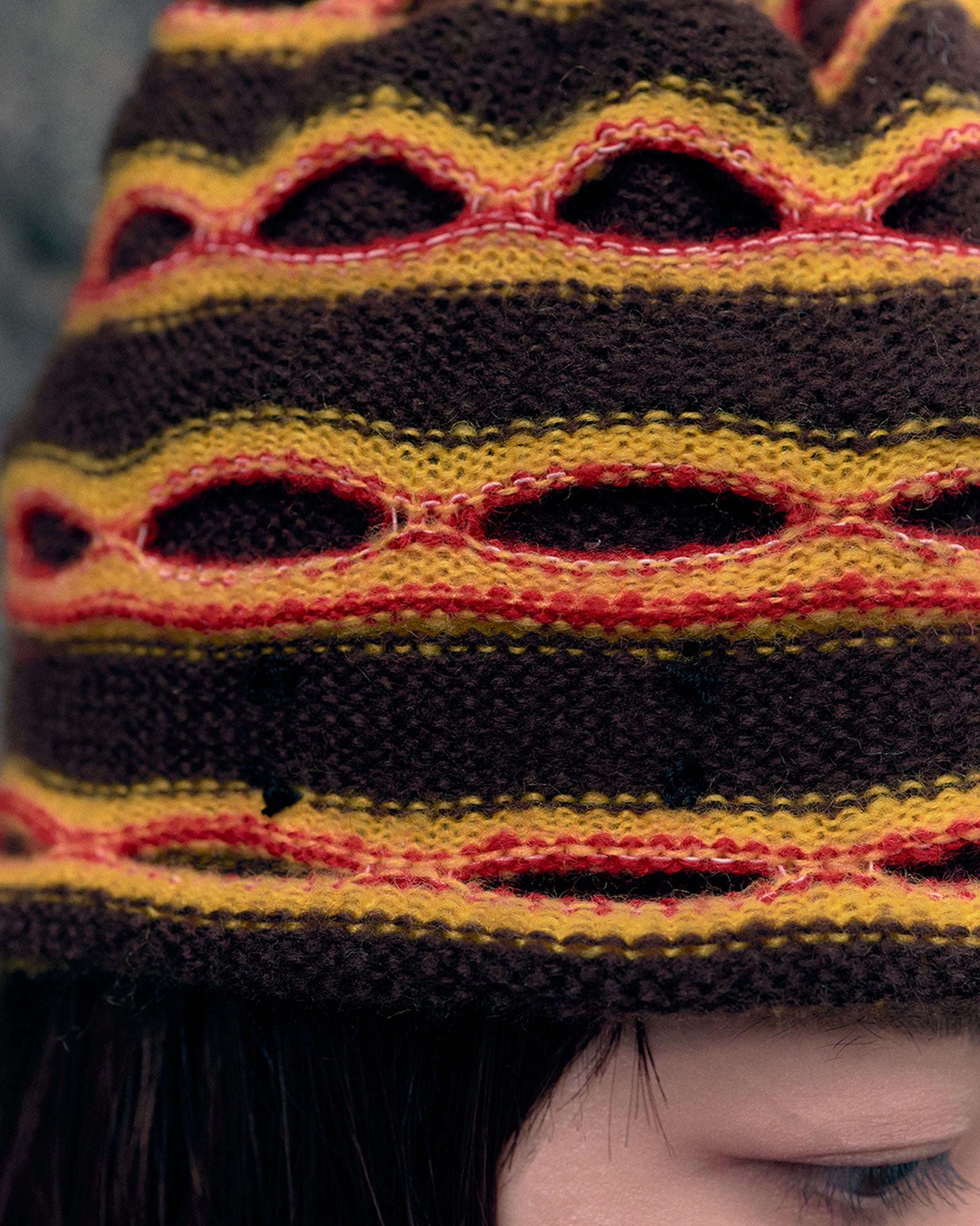 3d knit beanie with textured pattern worn on model
close-up of reversible knit beanie in brown and yellow stripes
side profile of wool mohair beanie with sculptural texture