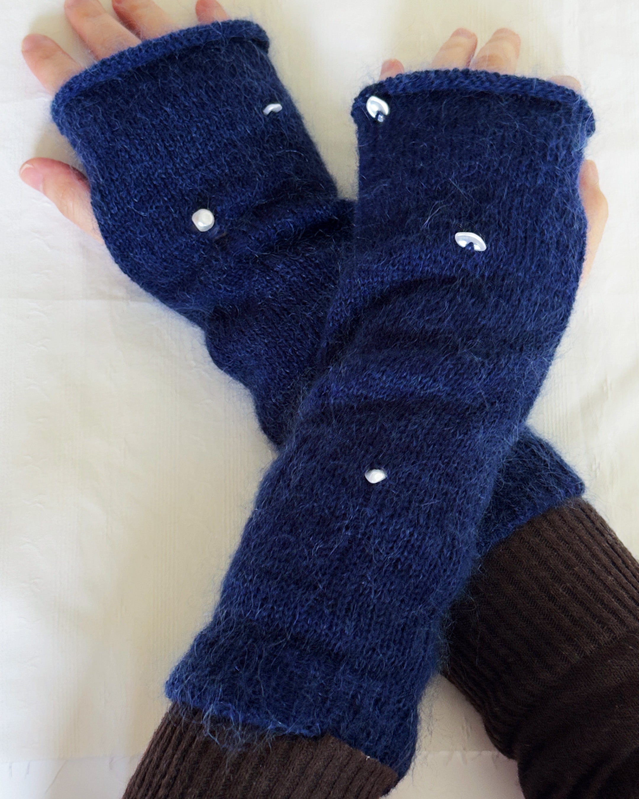 navy knit gloves with pearl details, merino wool and mohair texture close-up of handmade pearl gloves on neutral background soft knit fingerless gloves with pearl accents, wool mohair blend